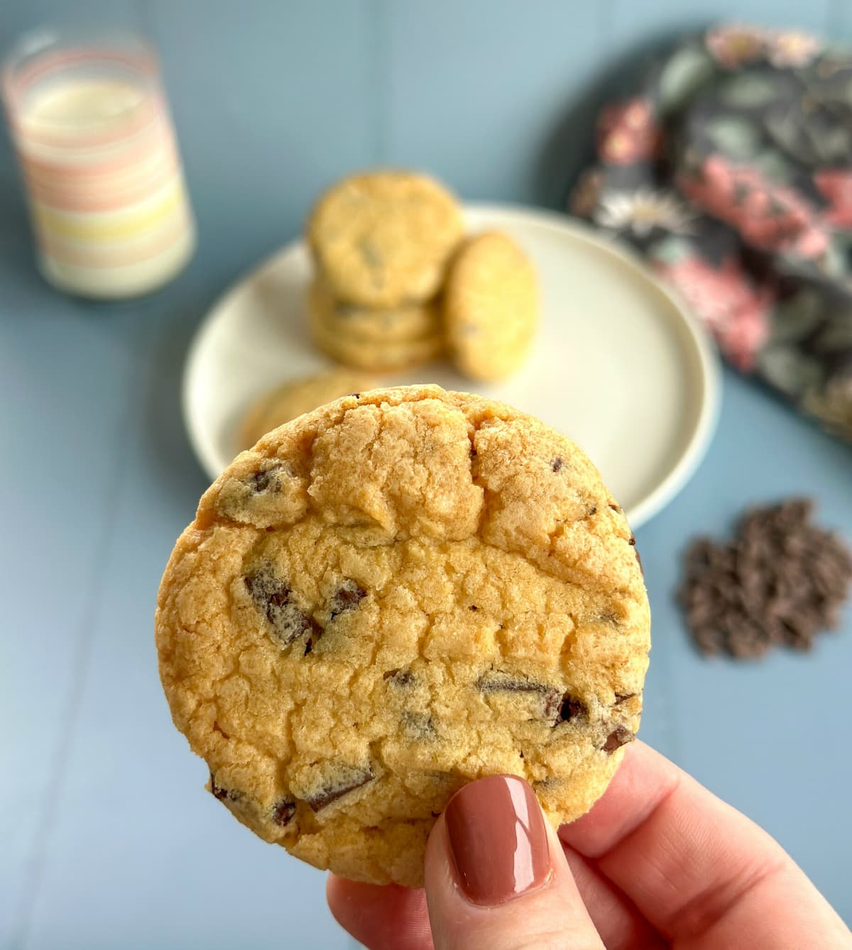 A hand with nailpolish holding a vanilla biscuit 