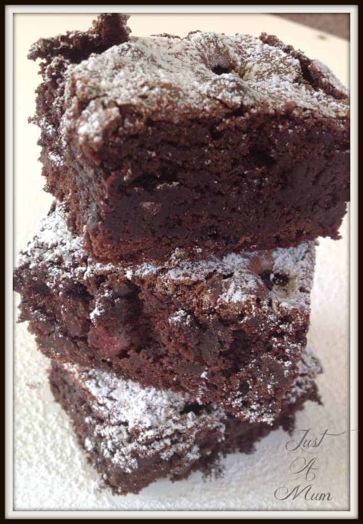 3 pieces of brownie in a stack dusted in icing sugar
