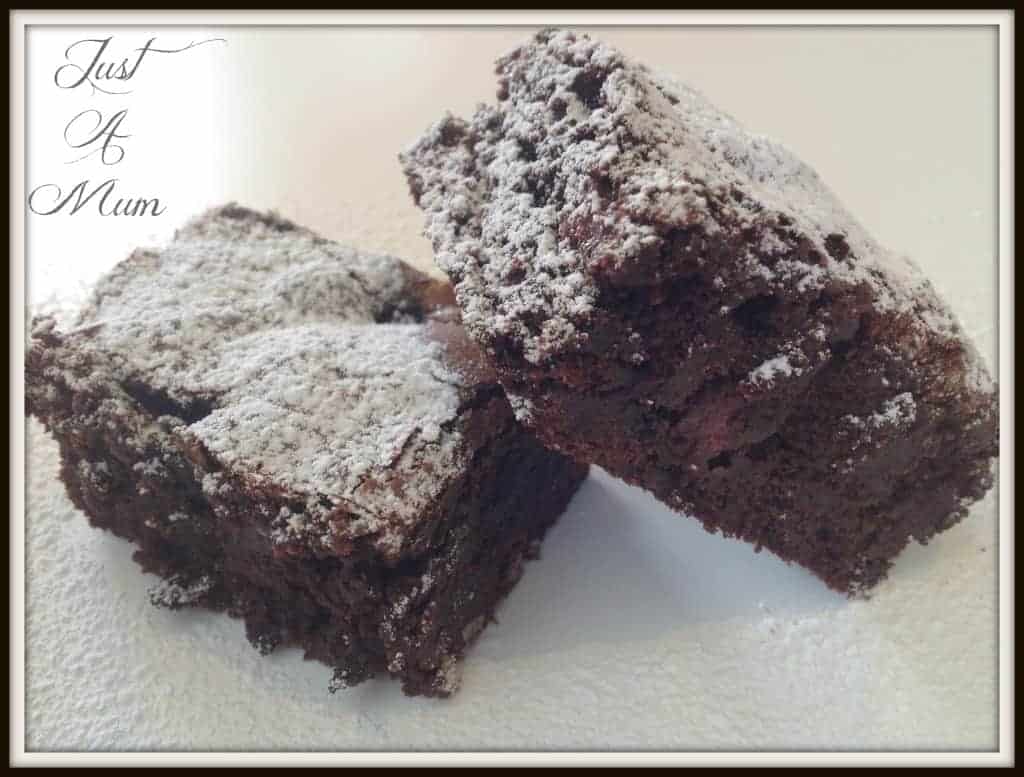 Two pieces of brownie dusted in icing sugar