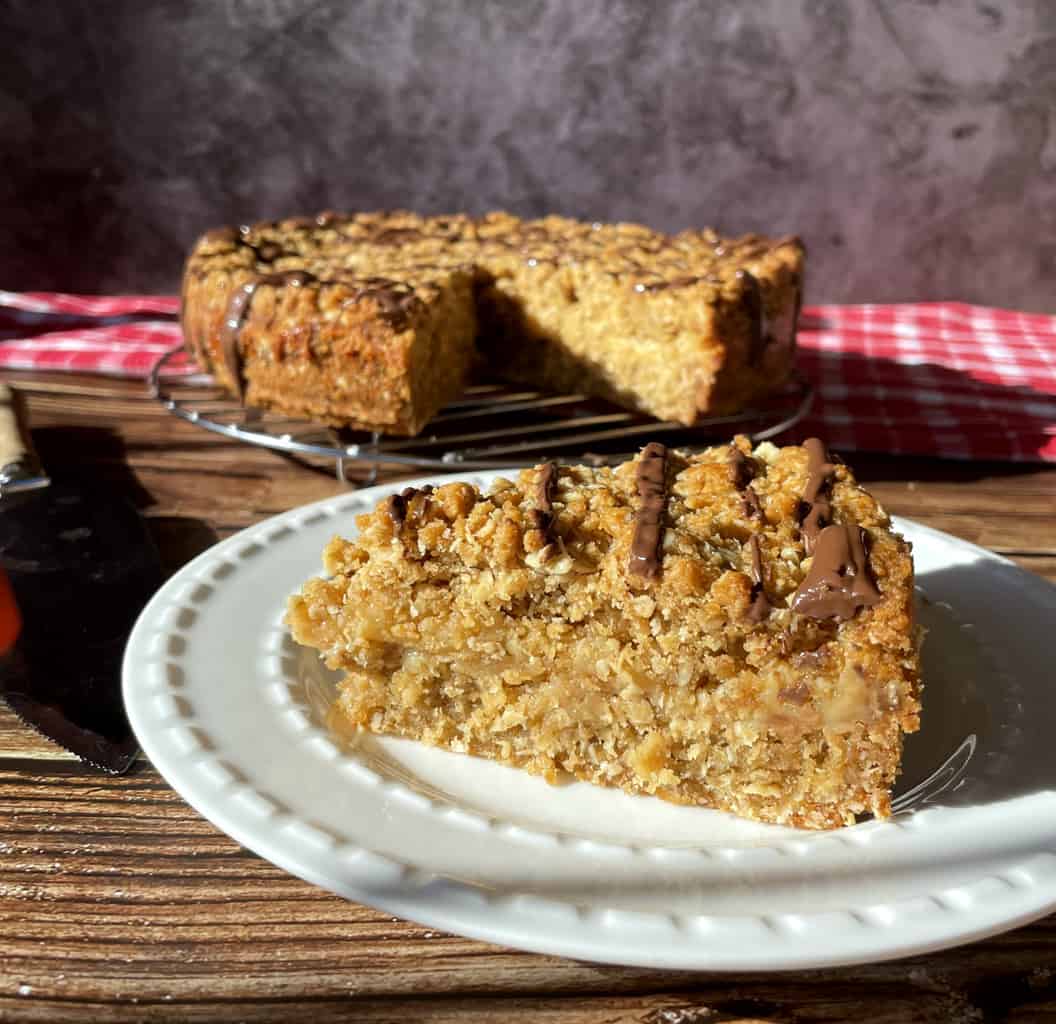 A photo of a slice of Anzac Slice with a caramel centre 