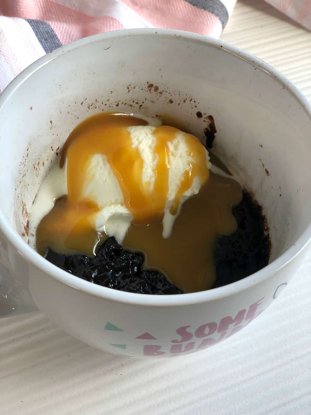 Bowl of Chocolate Self Saucing Mug Cake with ice cream and caramel sauce