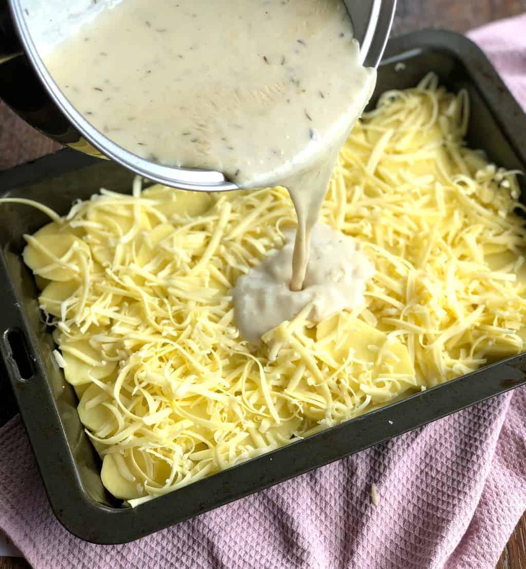 Pouring a Creamy Sauce for Scalloped Potatoes