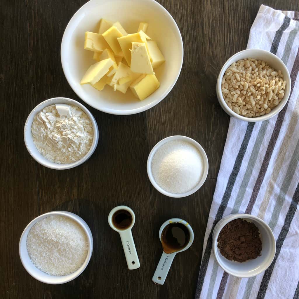 A flatlay photo of the ingredients to make chocolate chew slice in white bowls