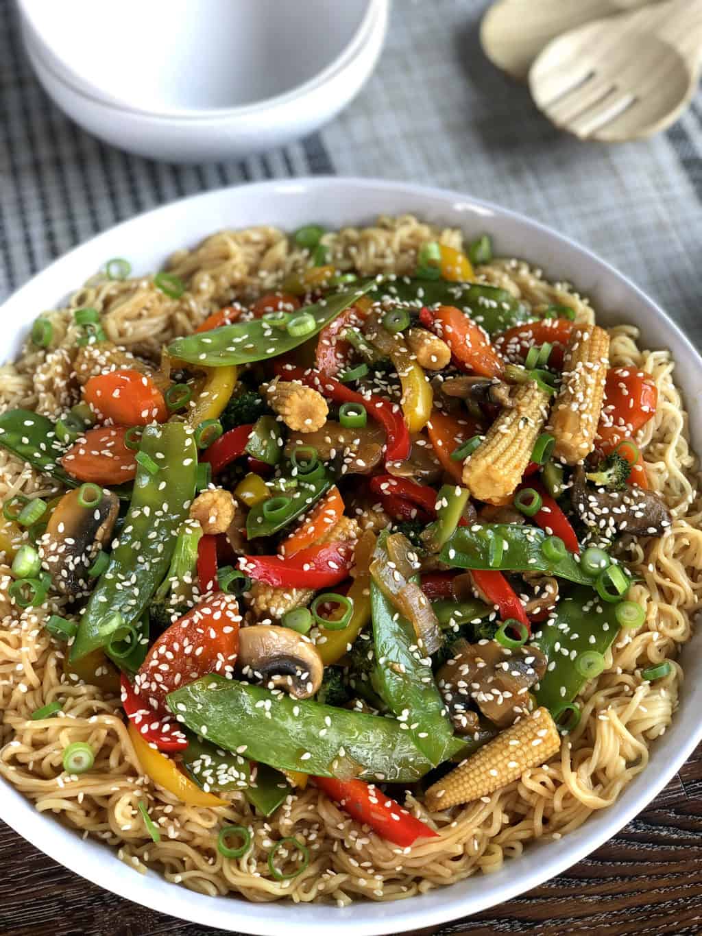 Large white serving bowl with egg noodles and vegetarian stir fried vegetables