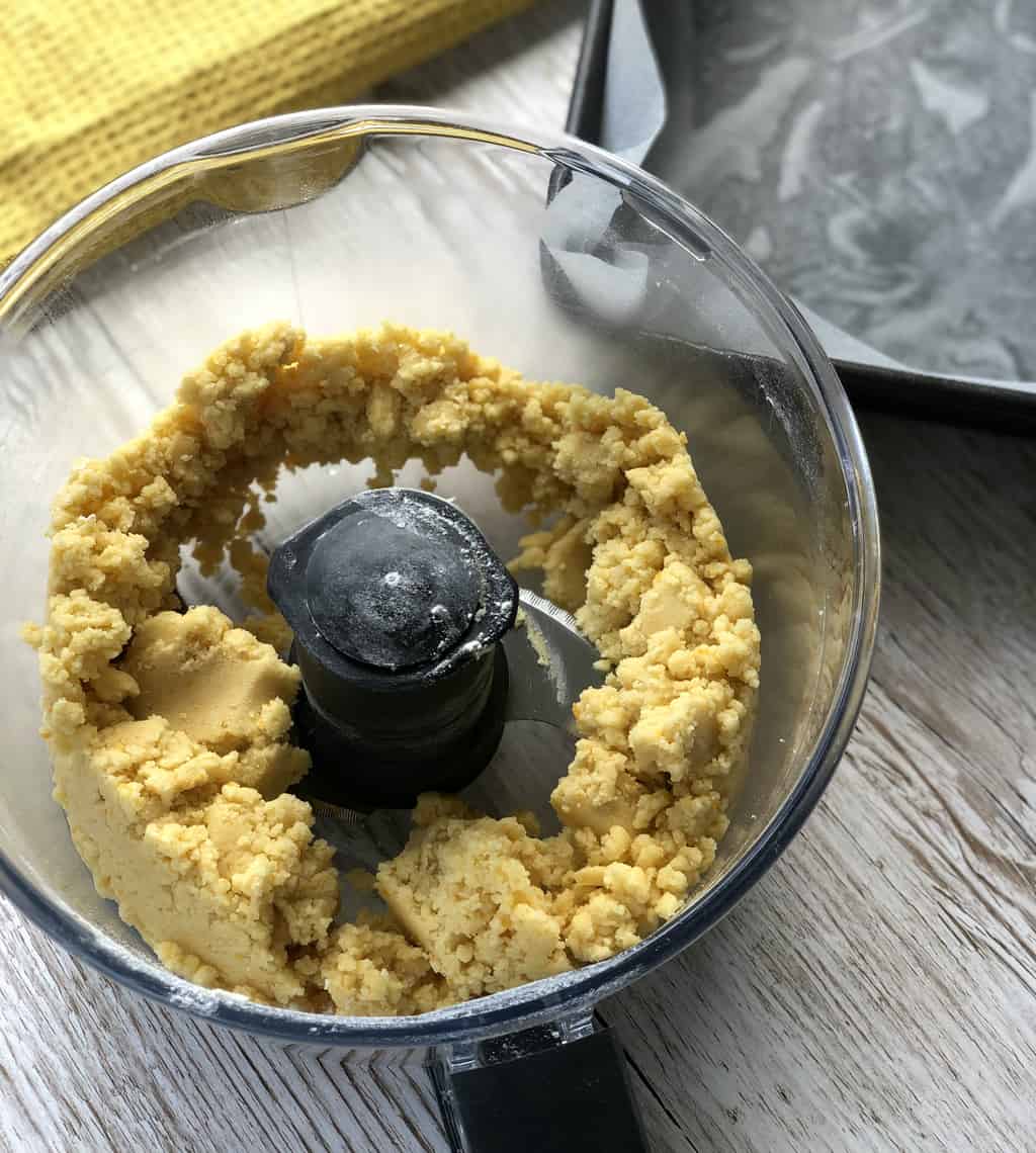 Photo showing the food processor bowl with the dough forming balls once combined 