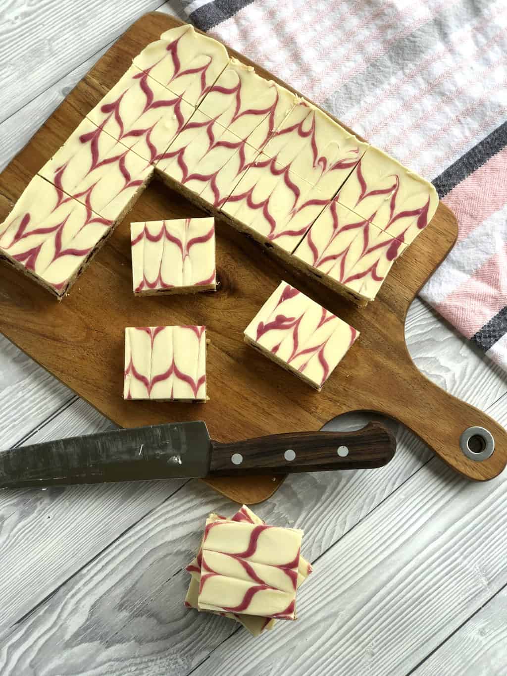 Overhead photo of a white chocolate no bake slice with a raspberry swirl topping