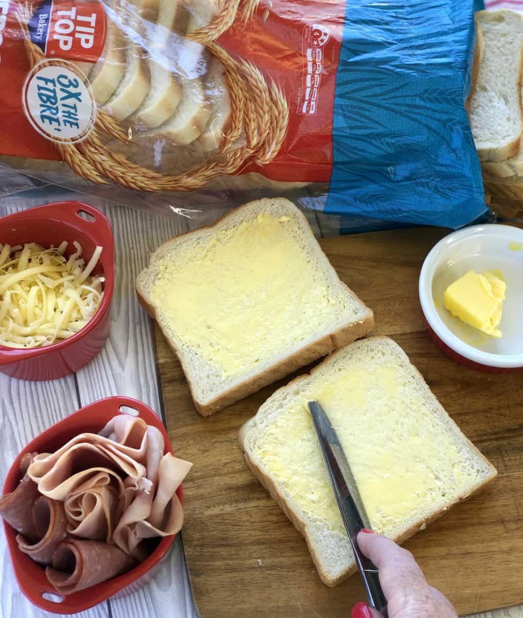 Preparing toasted sandwiches by spreading the butter 