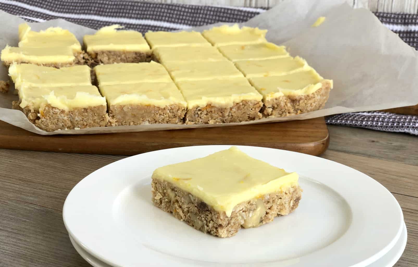 No Bake Biscuit Slice with orange icing, a single piece on a plate 