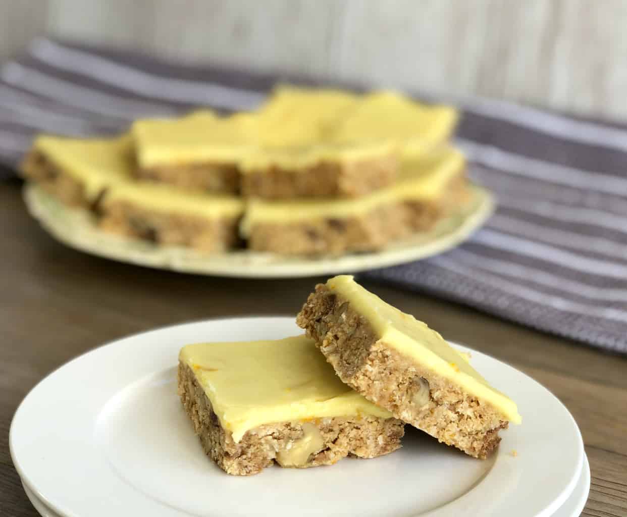 Two pieces of no bake orange slice with walnuts on a white plate