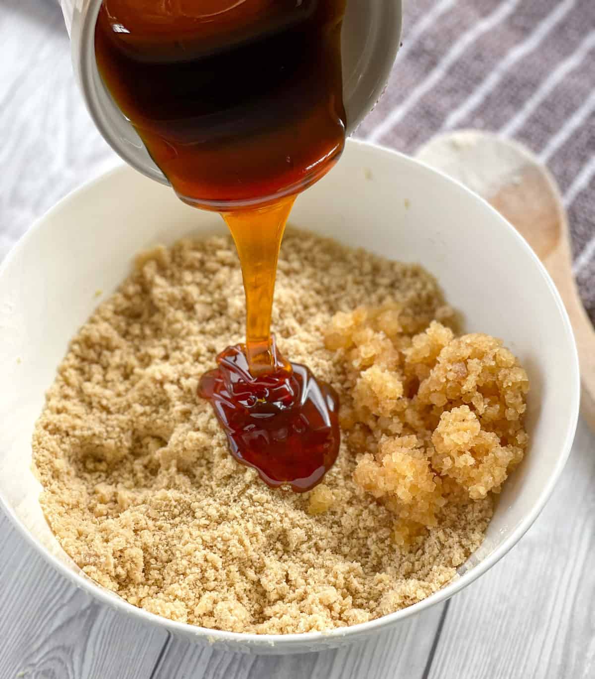 Pouring golden syrup over the flour and crystallized ginger 