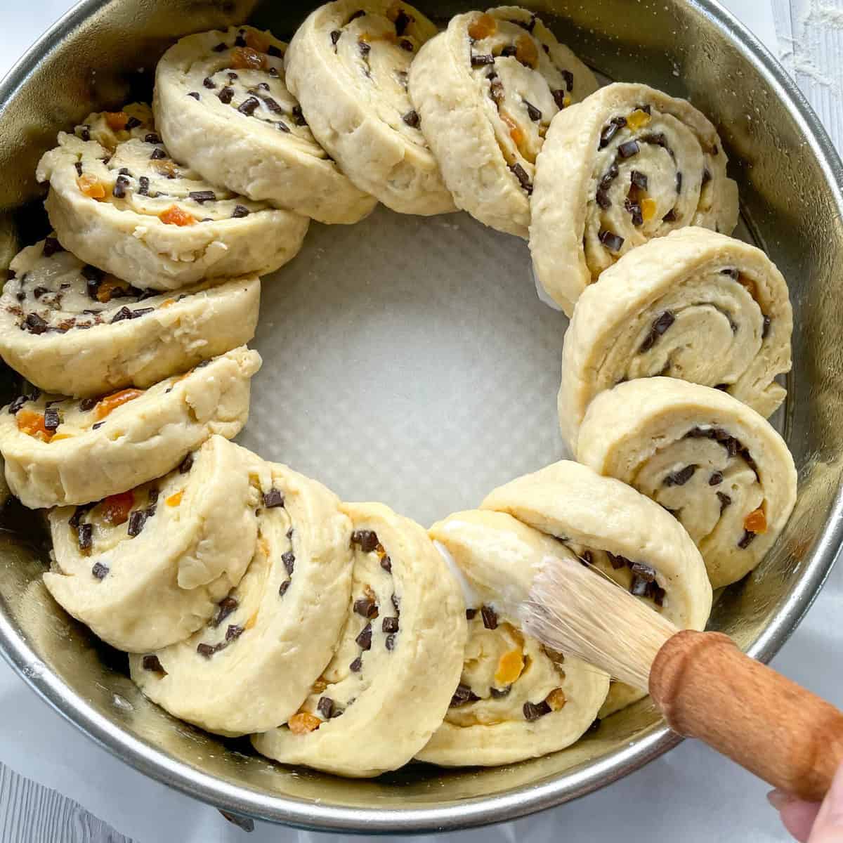 How to arrange the pieces of scrolls into the tin and glaze with milk