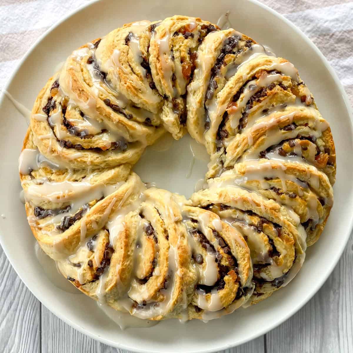 White platter with a wreath shaped Apricot and Chocolate Scrolls drizzled in vanilla glaze 