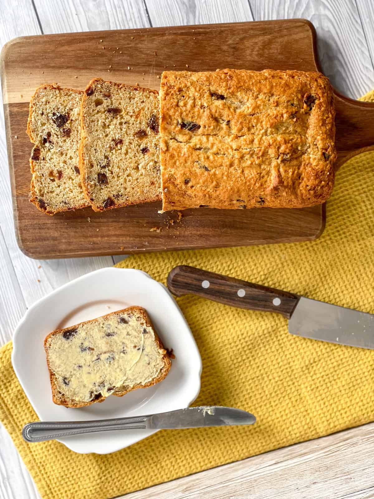 Overhead photograph of a sliced date and banana loaf and a piece with butter 