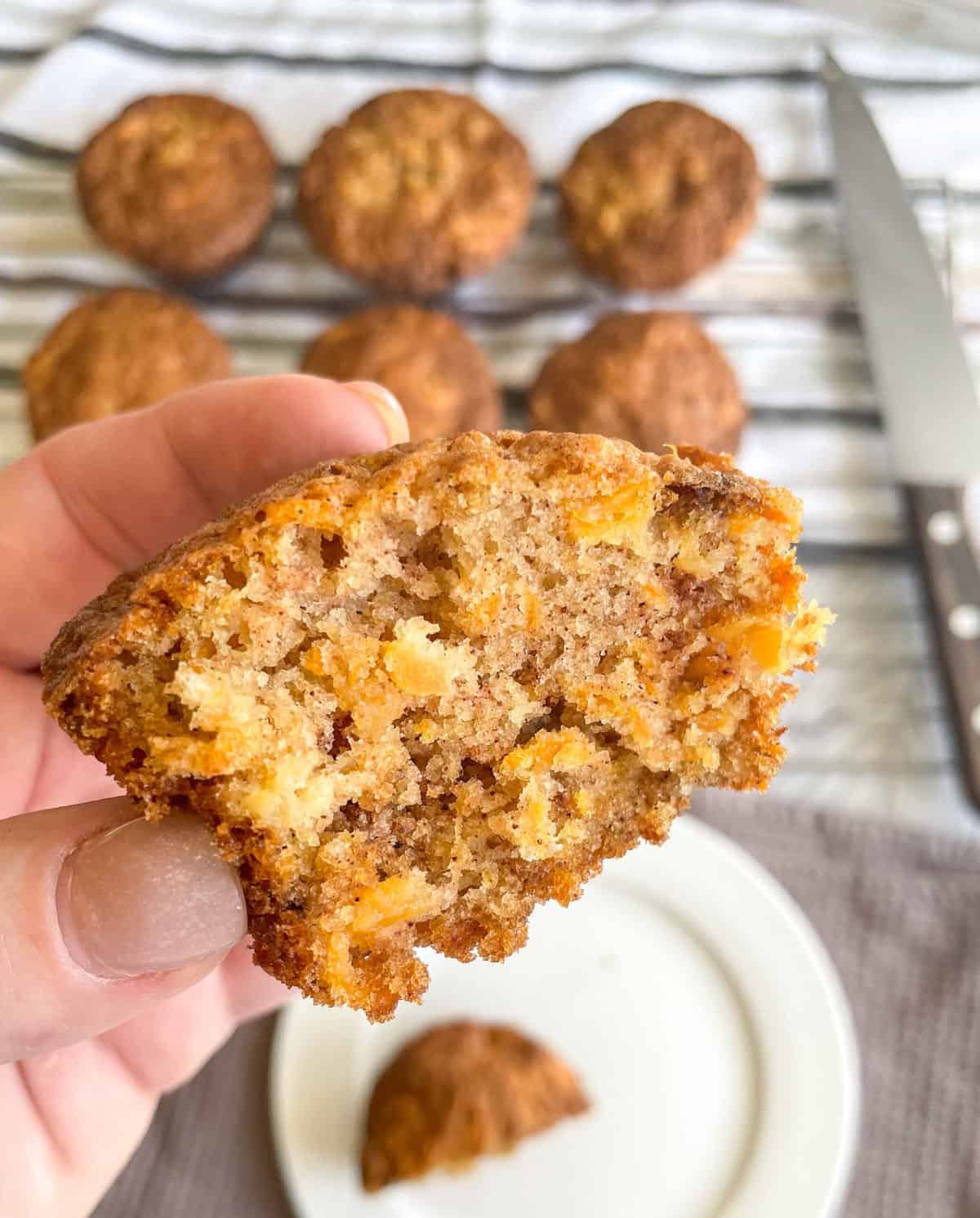 Half a muffin held in a hand showing the moistness and flavours 