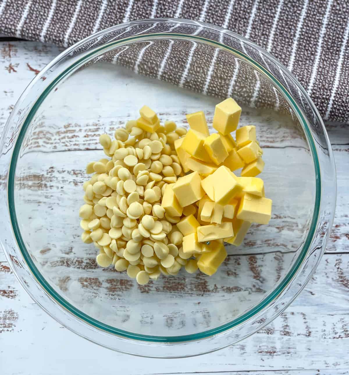 Glass bowl with white chocolate drops and diced pieces of butter