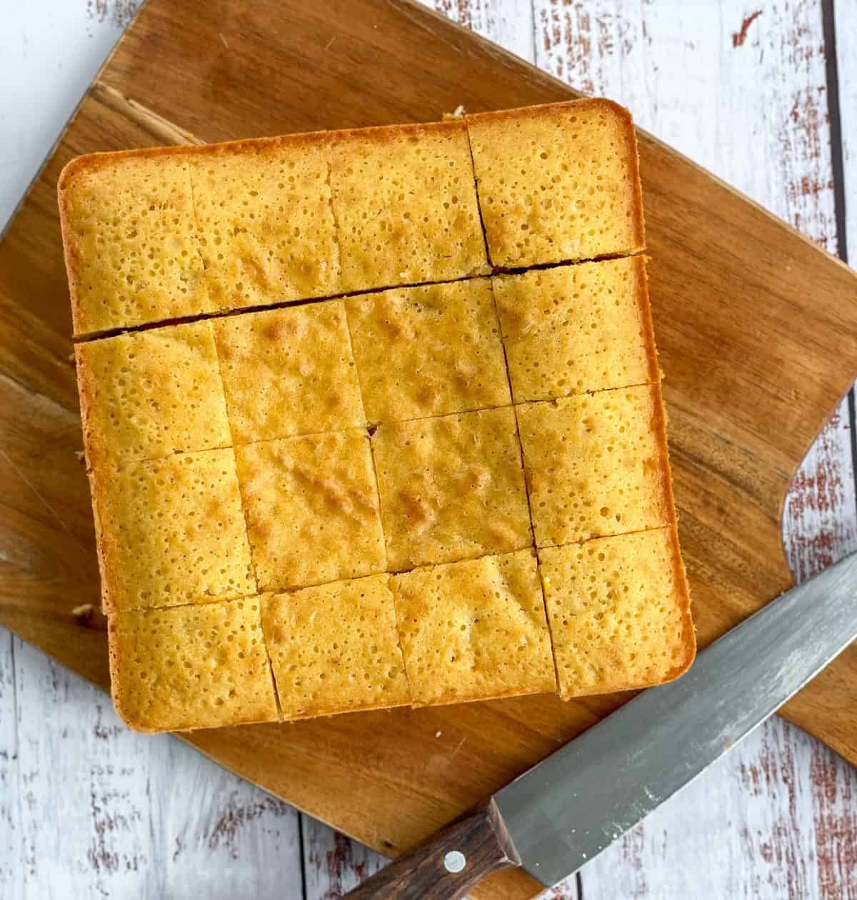 photo of a cut white chocolate and apricot slice on a wooden chopping board 