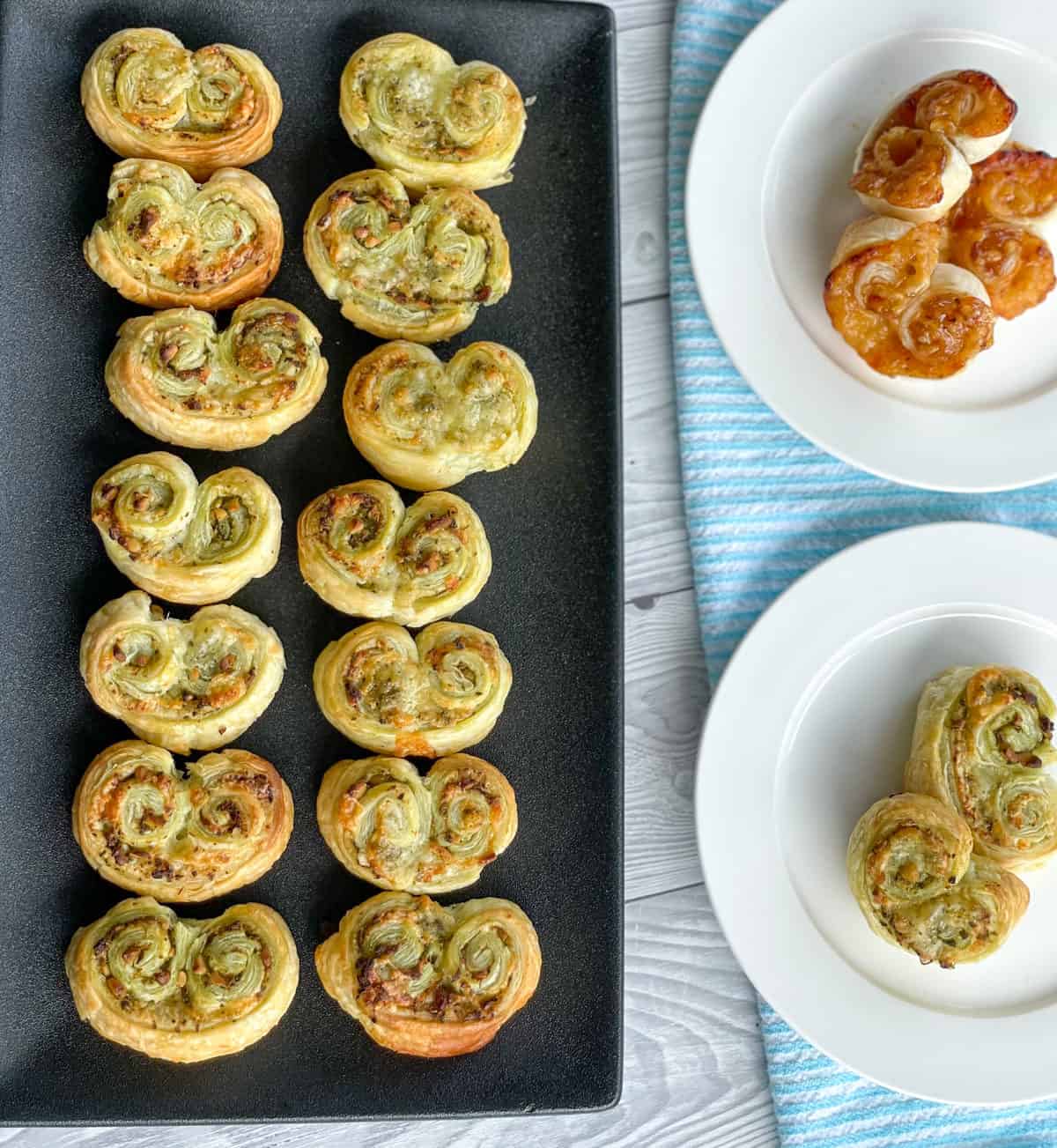 Savoury Palmier on a black plate and two white side plates 