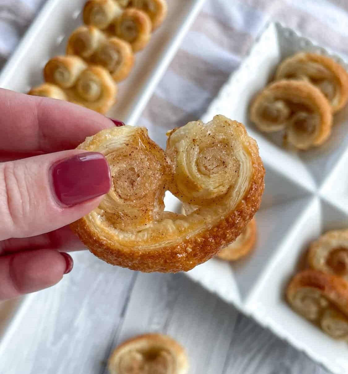 Hand holding a sweet sugar cinnamon palmier 