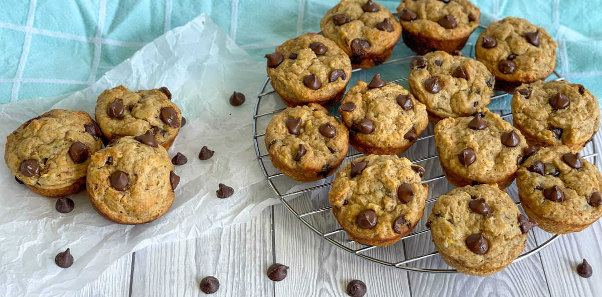 Muffins on a wire rack with three muffins off to the side and chocolate drops 