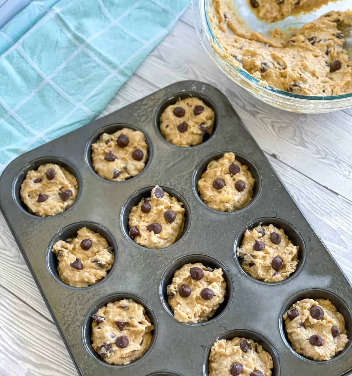 Greased muffin pan with muffin mixture ready to bake 