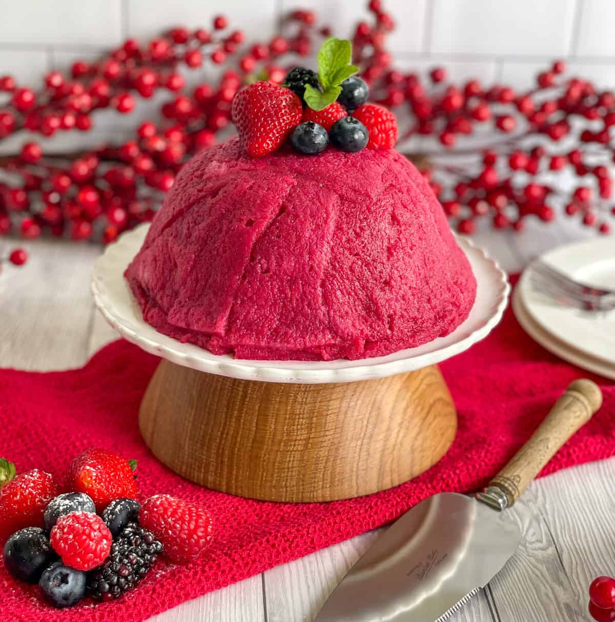 Summer Berry Pudding served on a white serving plate and topped with fresh berries