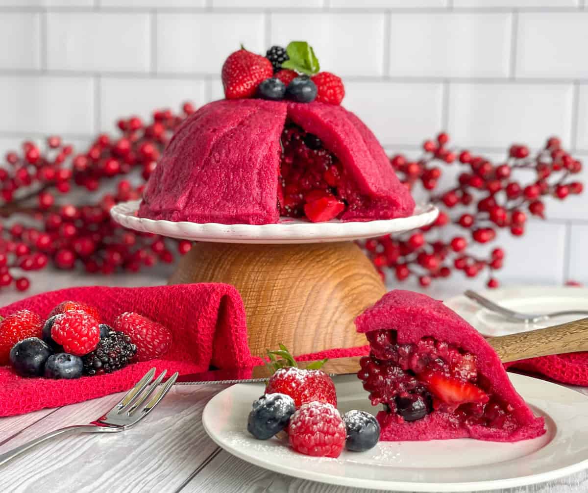 Summer Pudding with berries, sliced to show the bread outside and the berry syrup inside