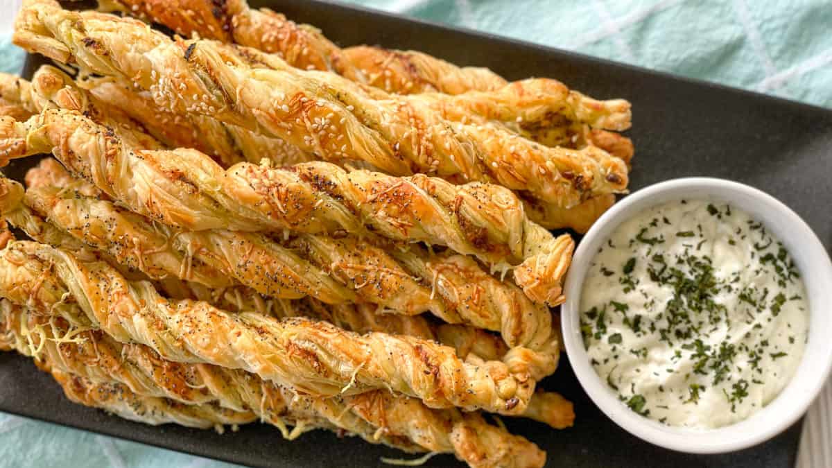 Pesto and cheese pastry twists on a black platter 