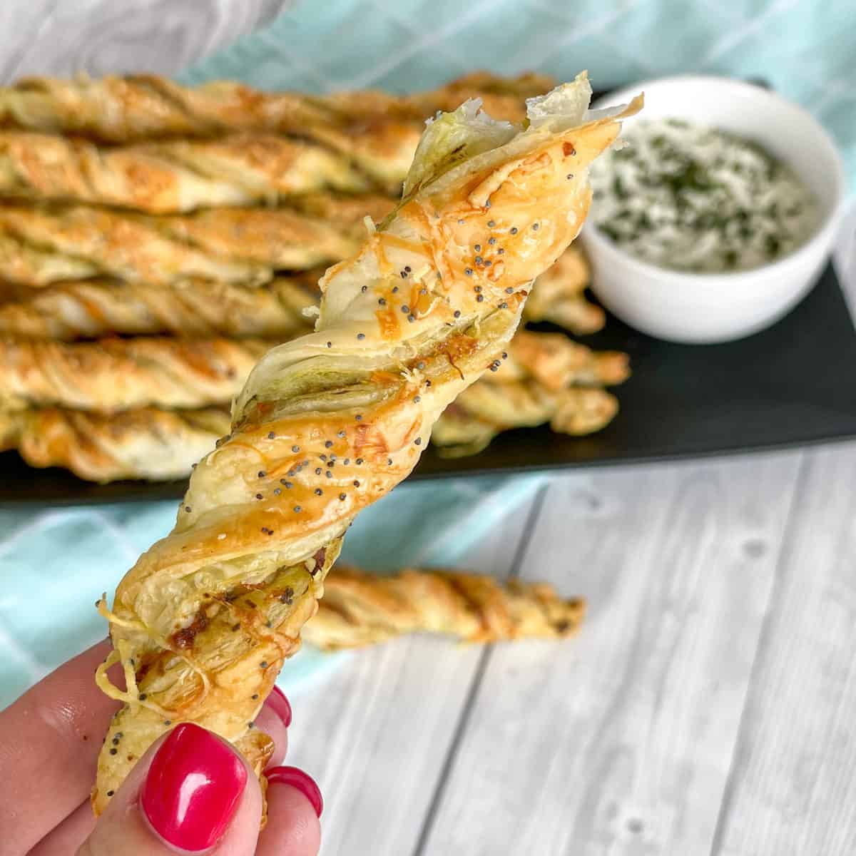 Hand holding a pesto cheese twist 