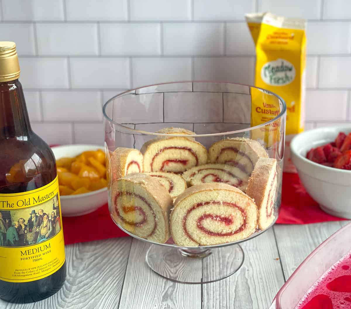 Prepare the sponge roll around the base of the trifle bowl, with the ingredients prepped ready to go