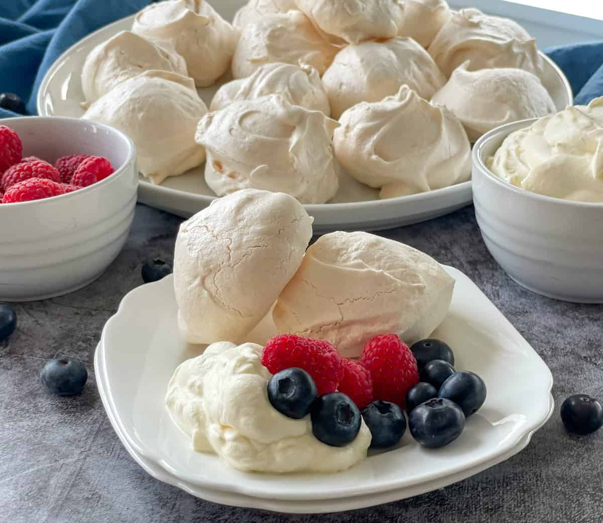 Meringues served with whipped cream, raspberries and blueberries 