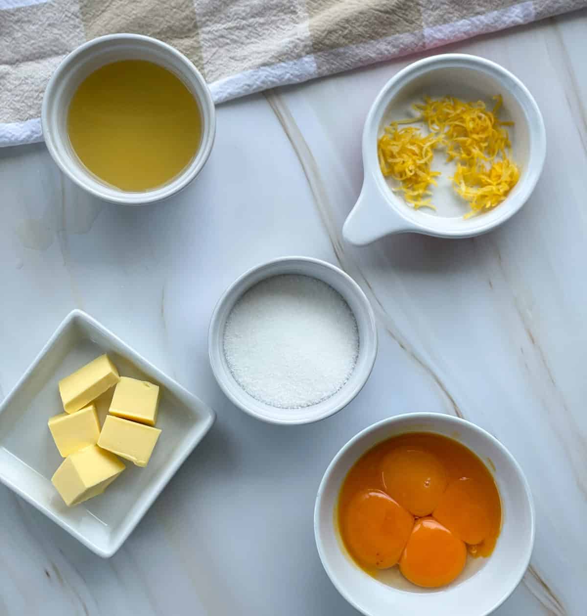 Ingredients used for lemon curd, lemon juice, lemon zest, butter, sugar and egg yolks. 
