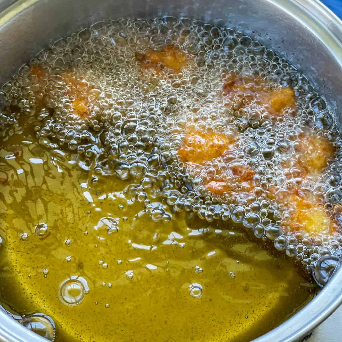Karaage chicken deepfrying in a saucepan 