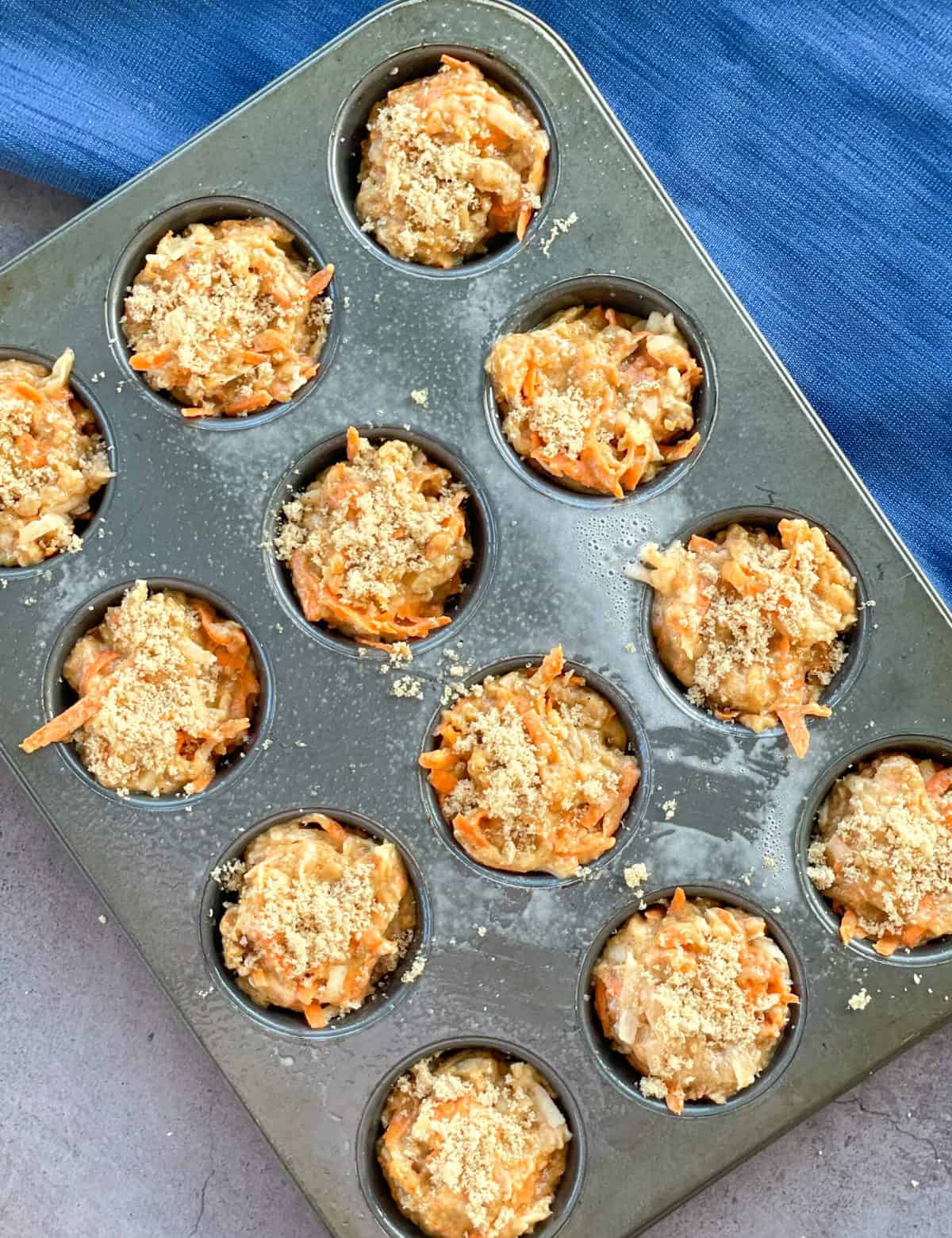 Brown sugar sprinkled on top of apple and carrot muffins before baking 