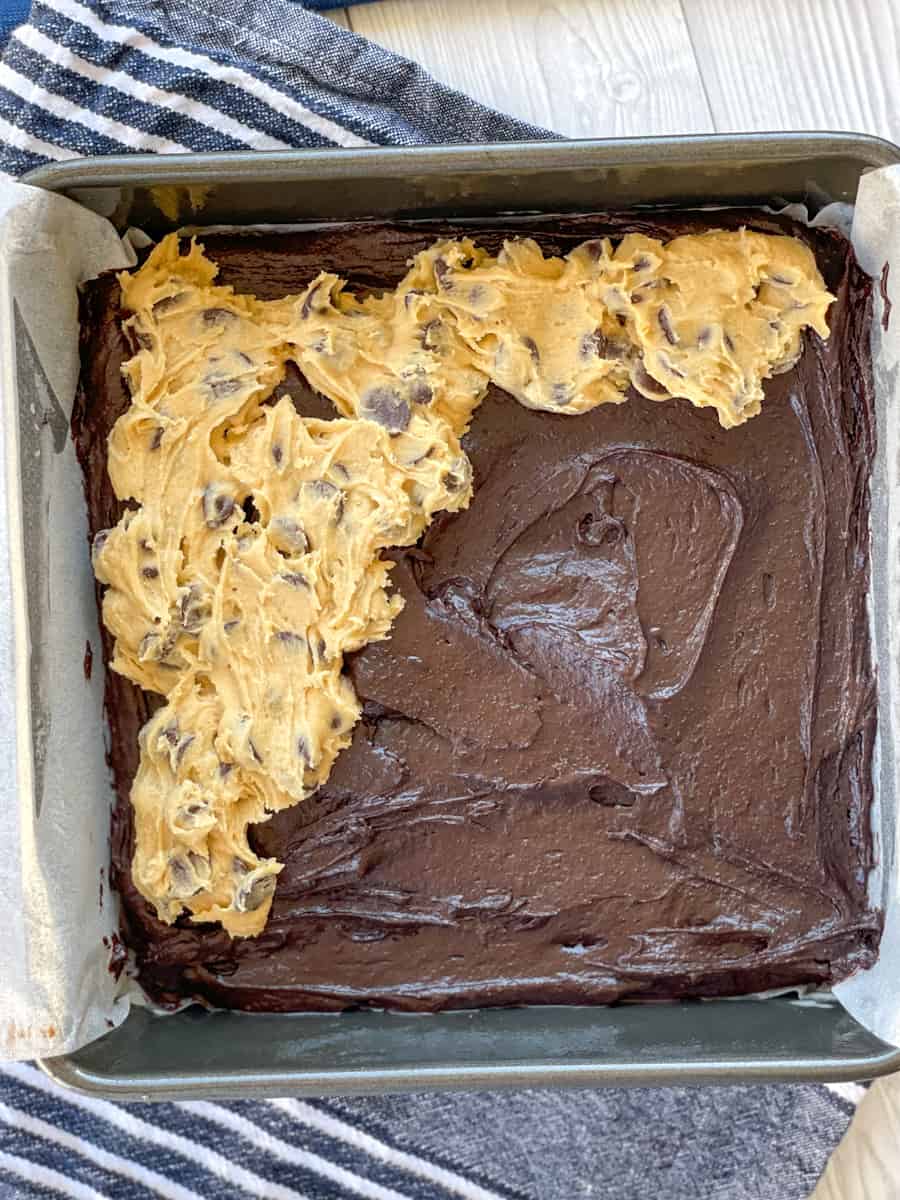 How to layer and spread spoonfuls of cookie dough over the brownie mixture