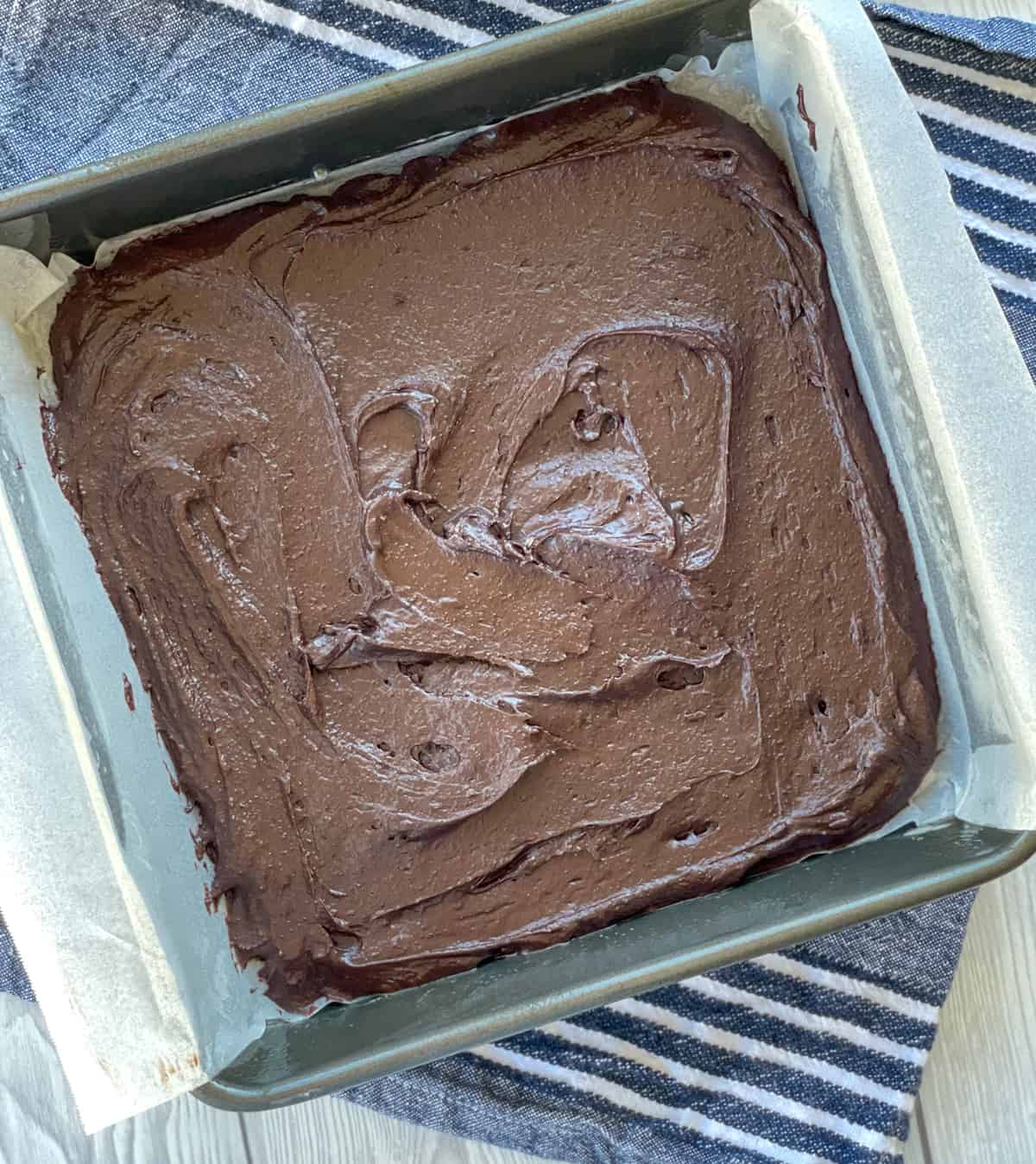 The brownie layer of the brookie spread in the pan with baking paper 