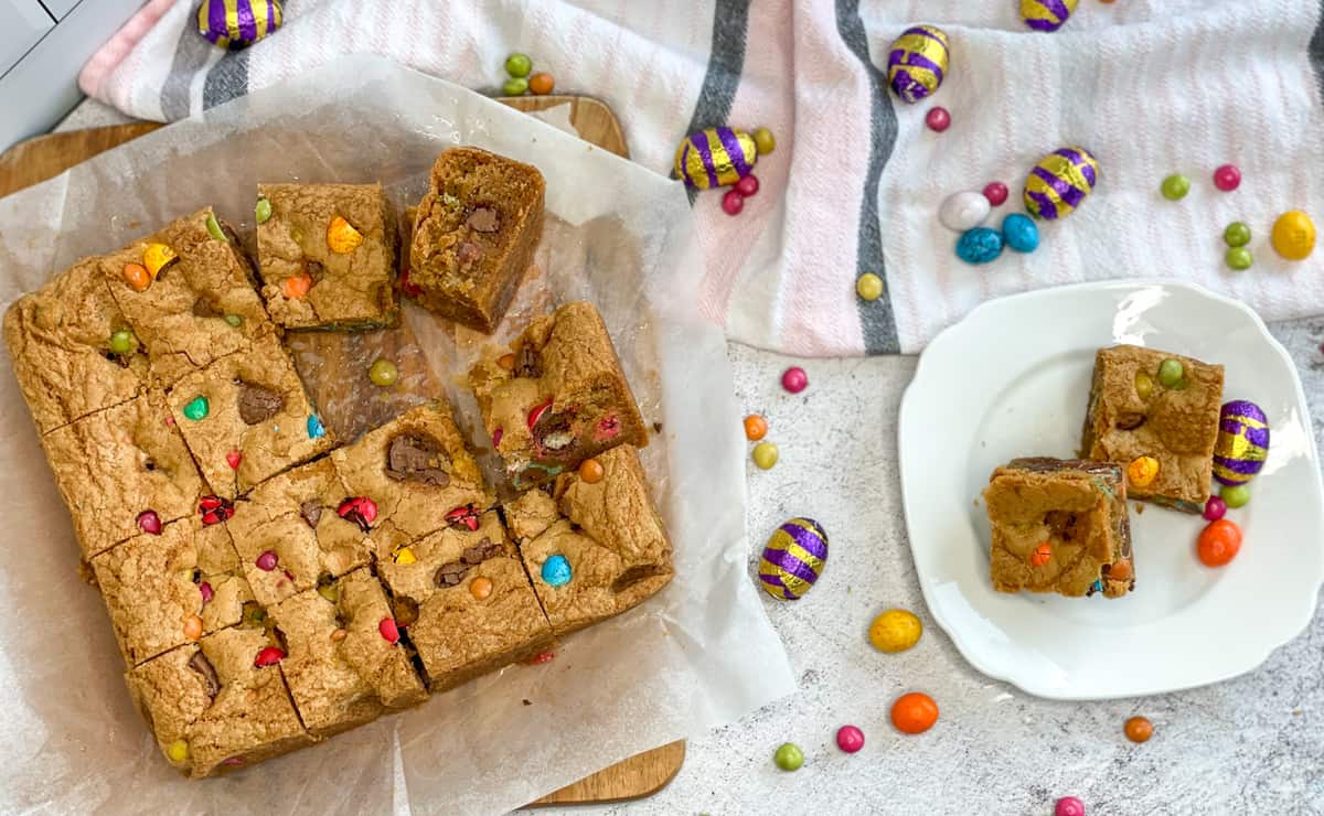 An Easter Cookie Slice, sliced into sqares on a white background surrounded by mini easter eggs