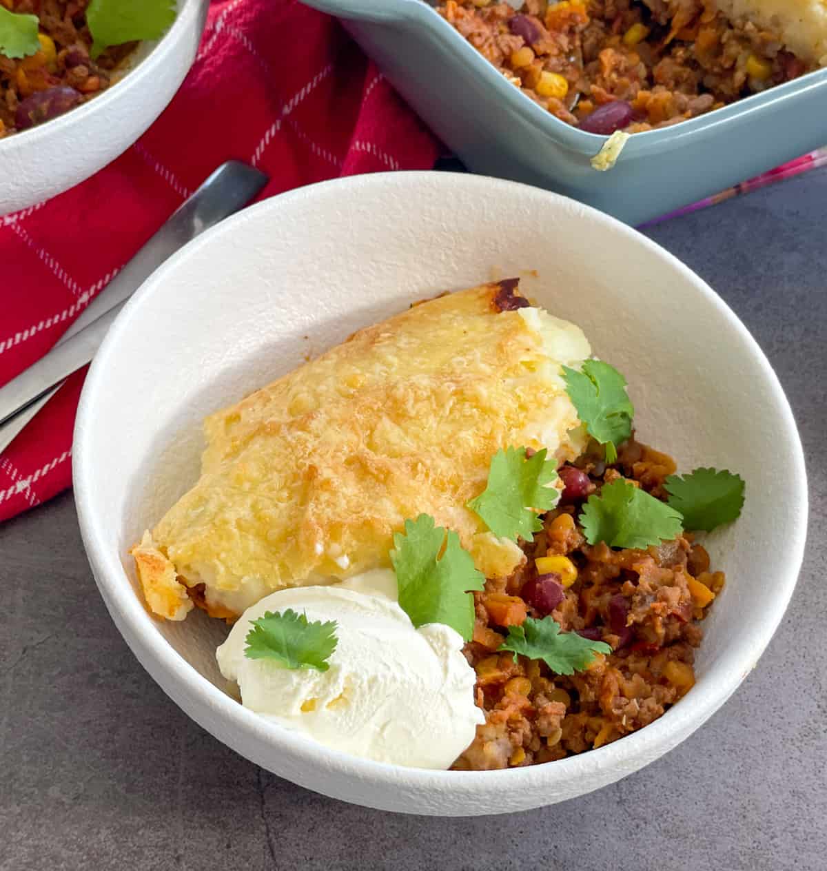 A bowl of chilli con carne potato top pie with coriander 