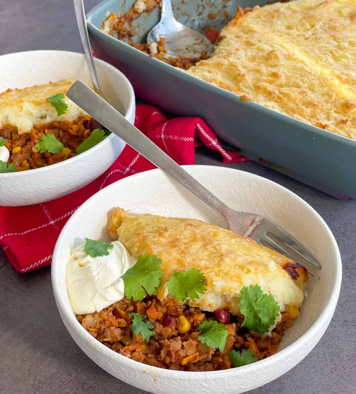 Two white bowls of chilli con carne potato top pie