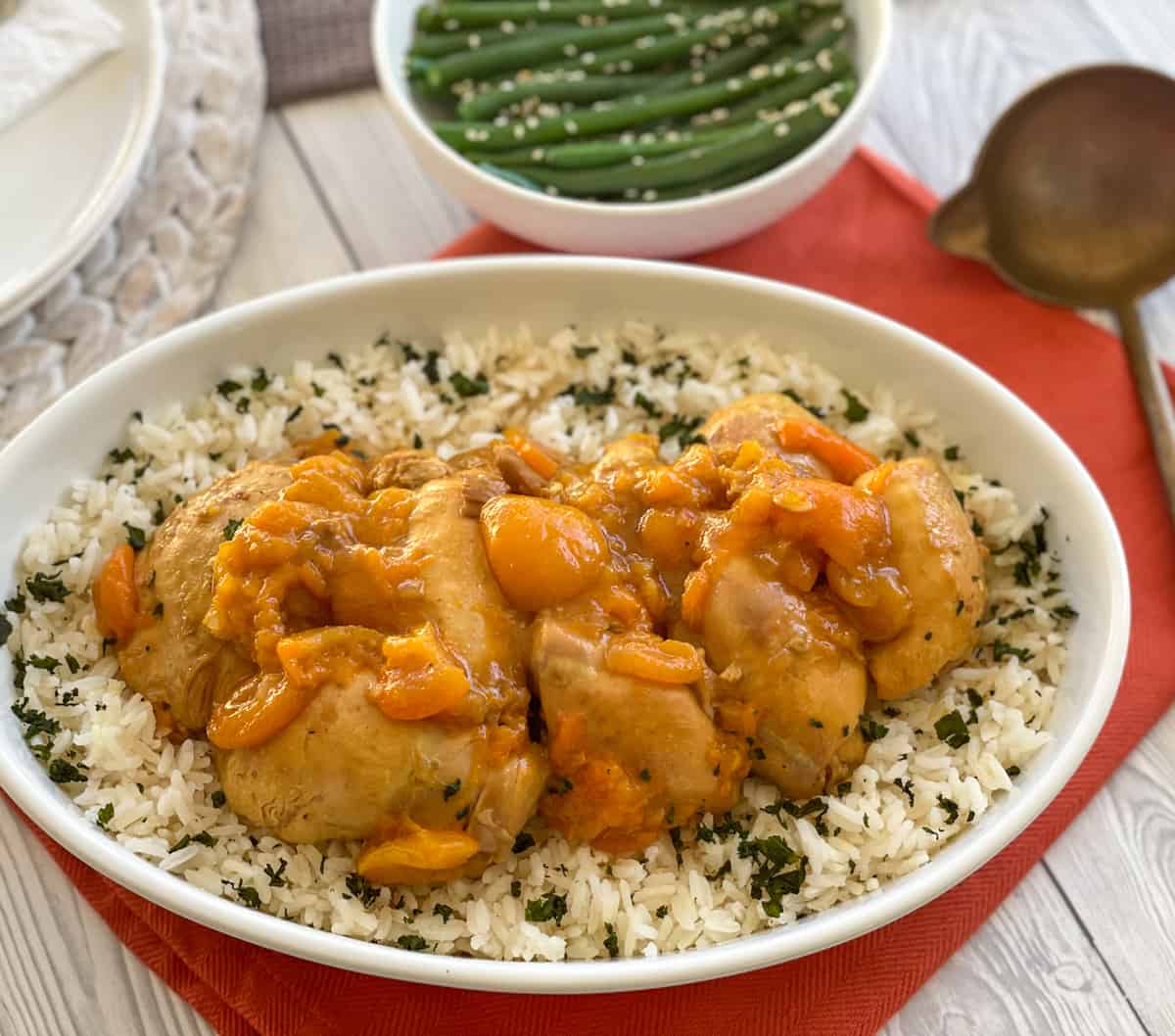 Bowl of apricot chicken over rice with beans 