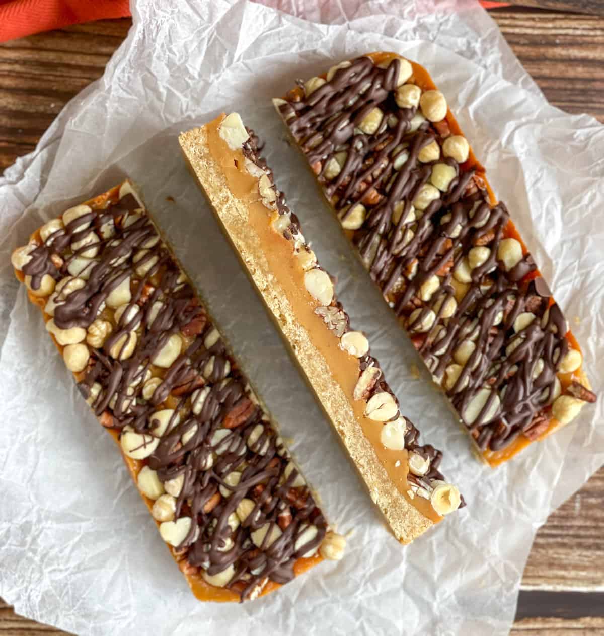 Cross section of caramel nut slice drizzled in chocolate 