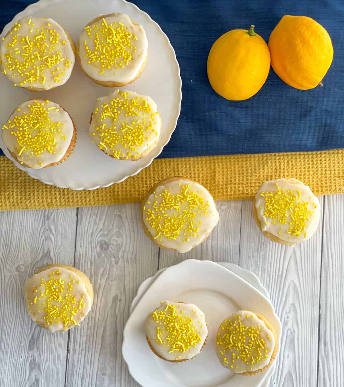 Overhead photograph of lemon cupcakes with white lemon icing and yellow sprinkles
