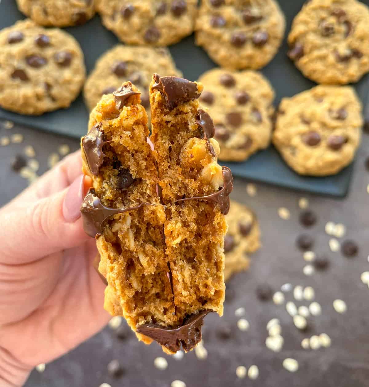 Fresh hot peanut butter cookie broken in half with melted chocolate drops