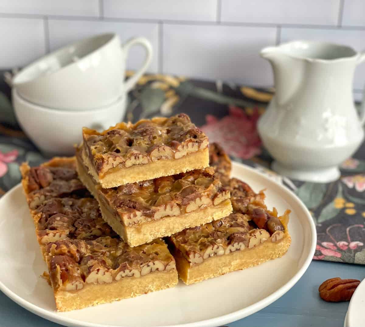 A white plate with pecan caramel slice