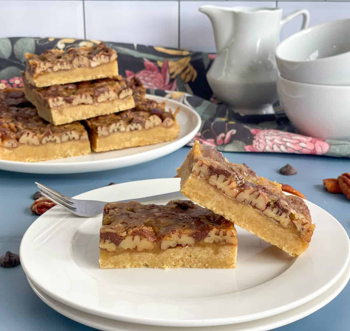 Two pieces of pecan caramel slice on a white plate