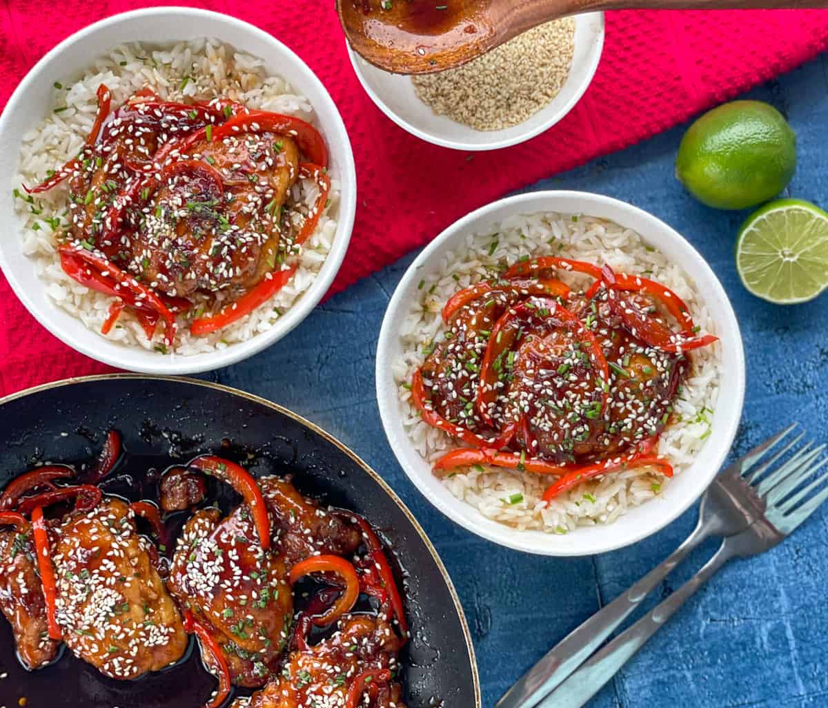 Easy Sticky Glazed Chicken Thighs, recipe in two bowls with rice and lime to serve