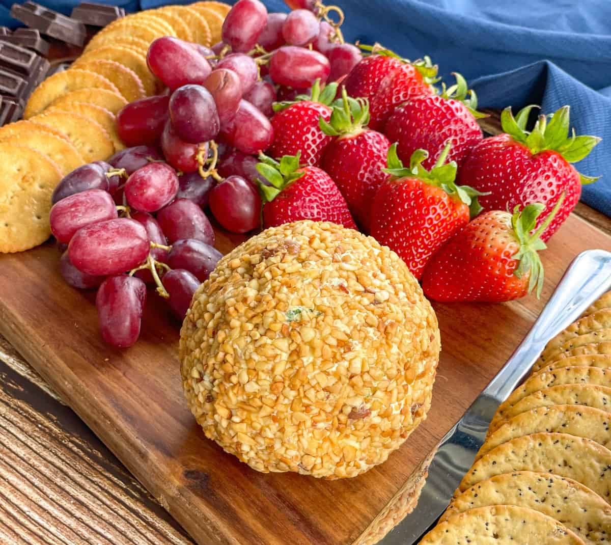 Homemade Cheeseball on a platter with grapes, strawberries and crackers 