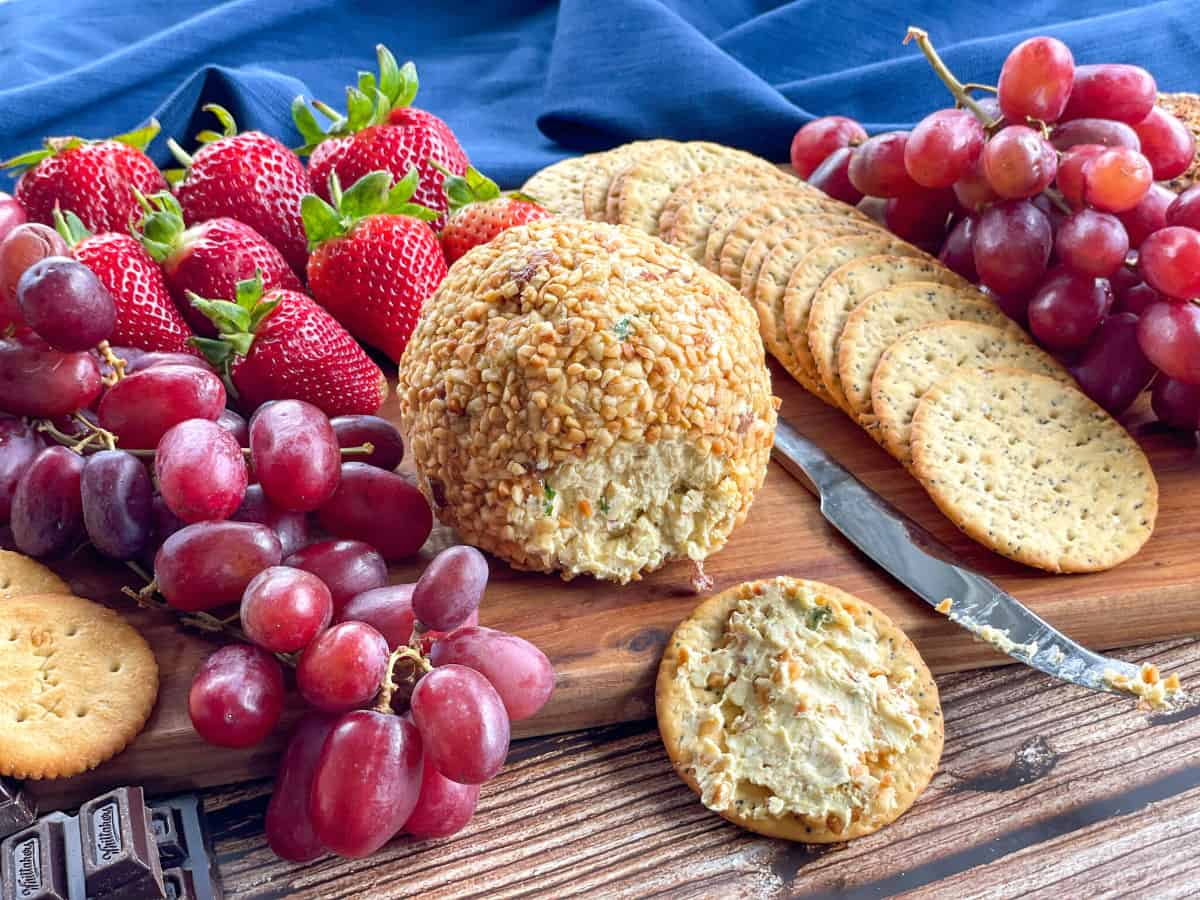 Peanut rolled cheeseball with crackers and a fruit and chocolate platter 