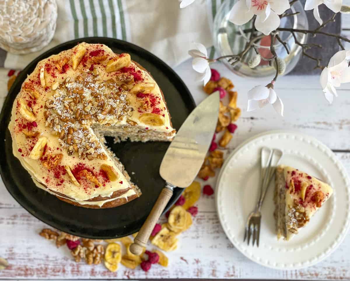 Overhead photograph of hummingbird cake with cream cheese frosting and decorations 