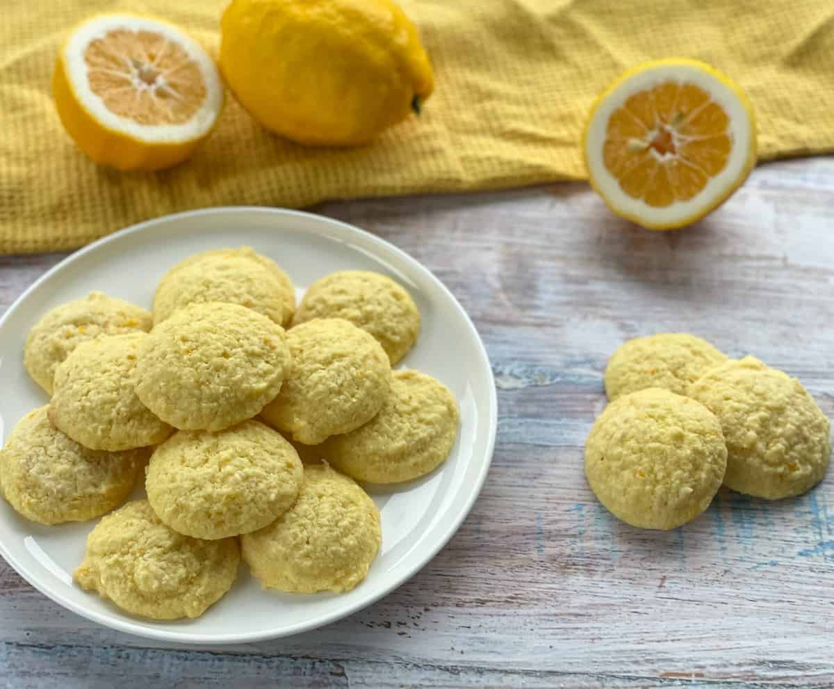Plate of lemon and coconut cookies with whole lemons as decoration