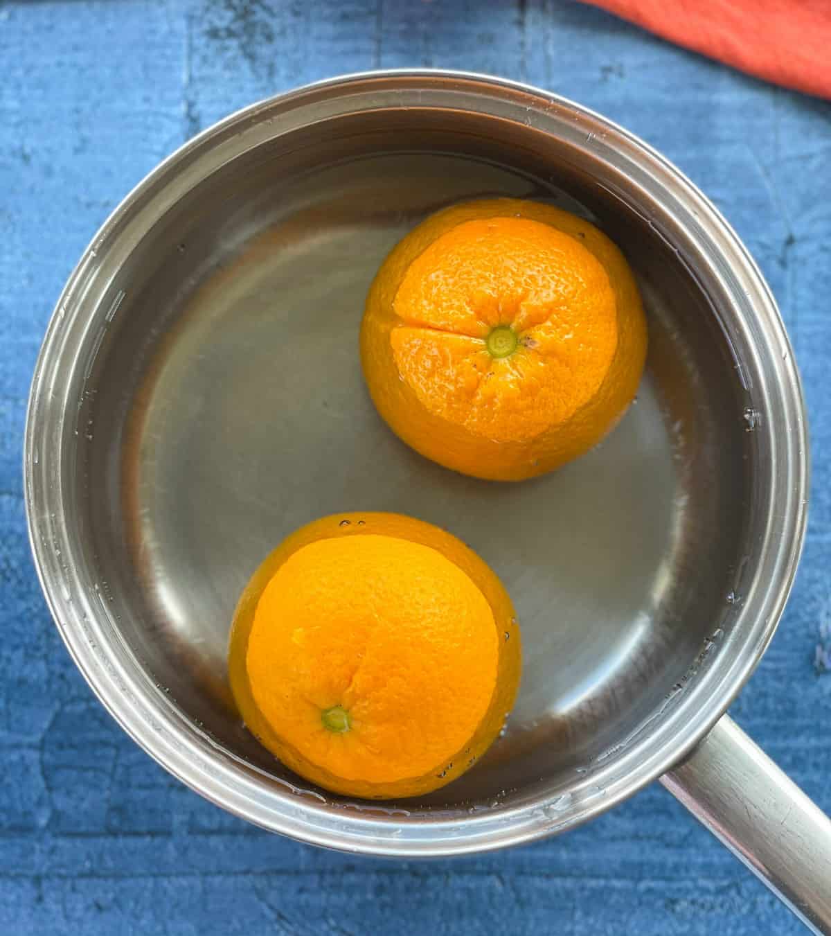 How to boil whole oranges for an orange and almond cake in a saucepan covered in water